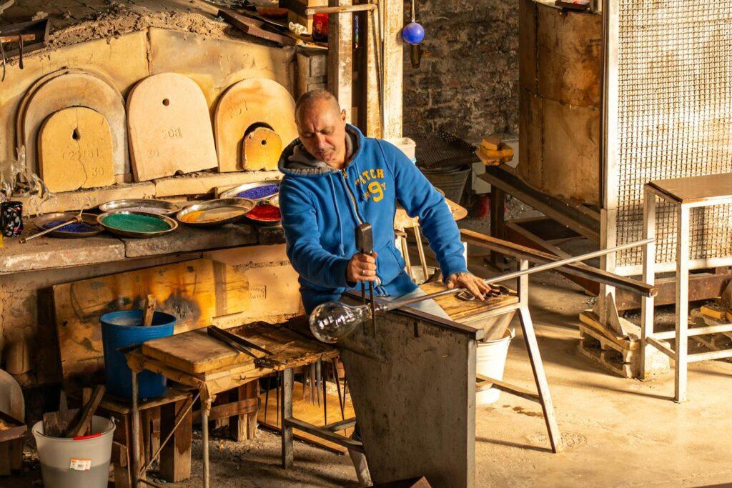 Artigiano del vetro al lavoro in una bottega
