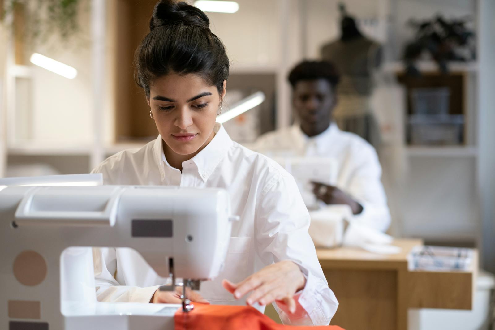 Atelier di moda con persone al lavoro su tessuti